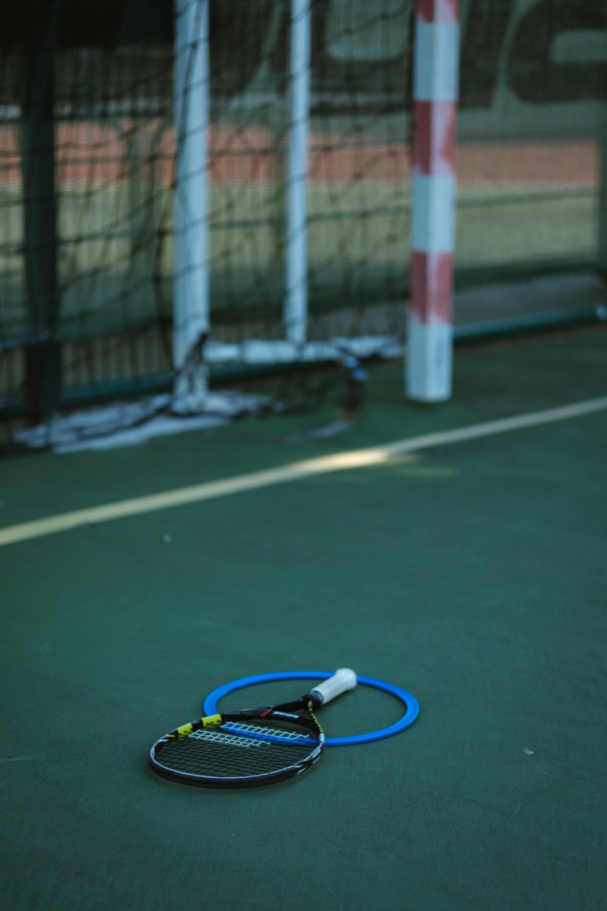 Raquette et cerceau au pied d'une cage de handball