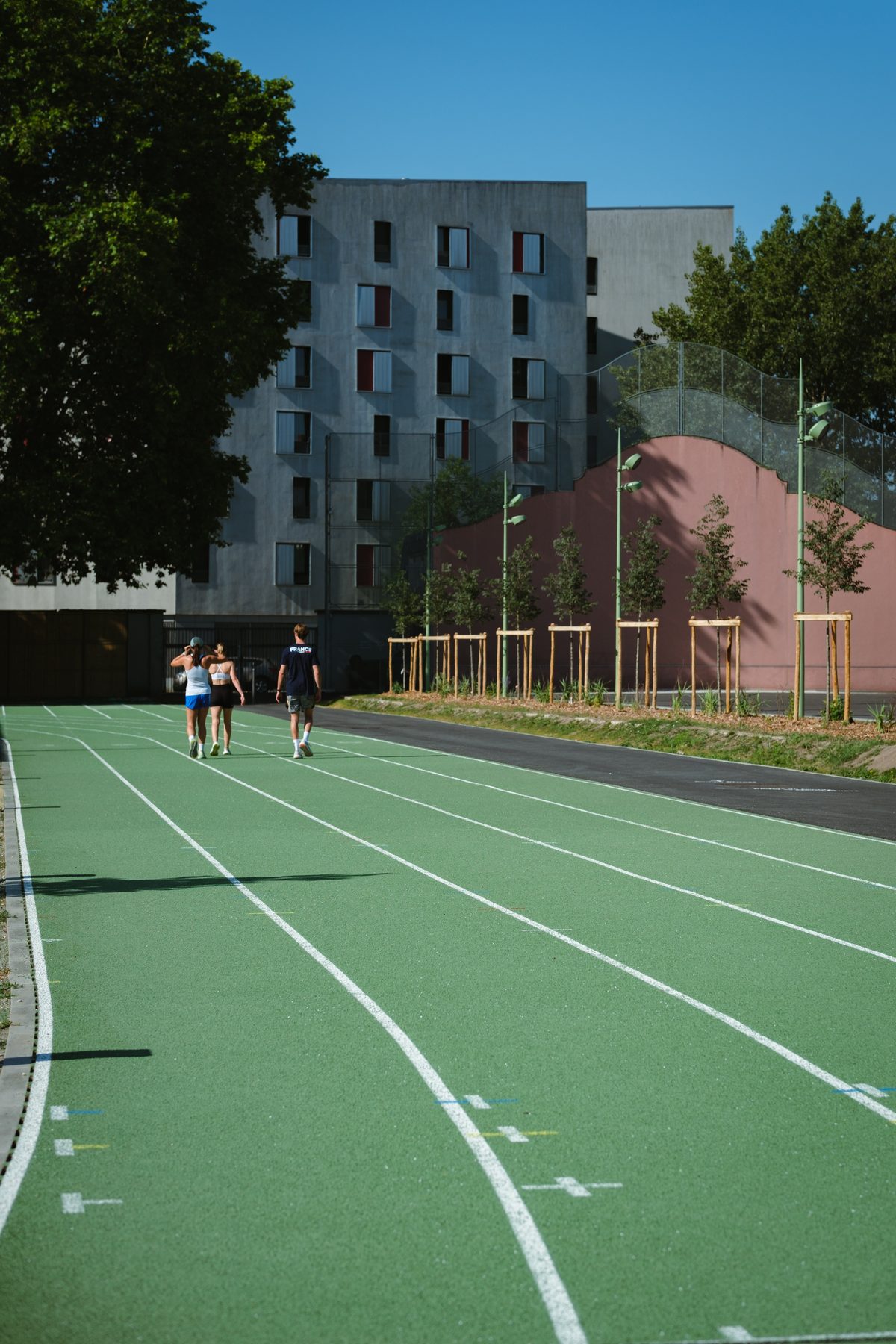 Piste d'athlétisme, trois athlètes de dos